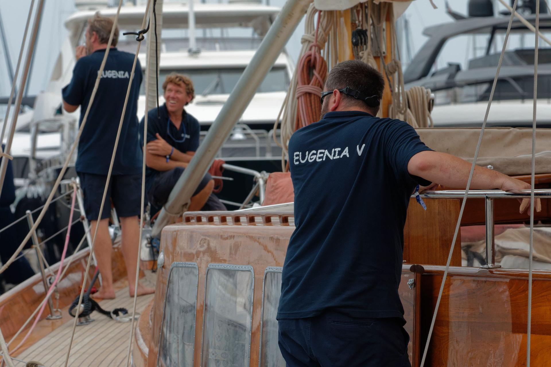 Crew members working together on the deck of a classic sailing yacht